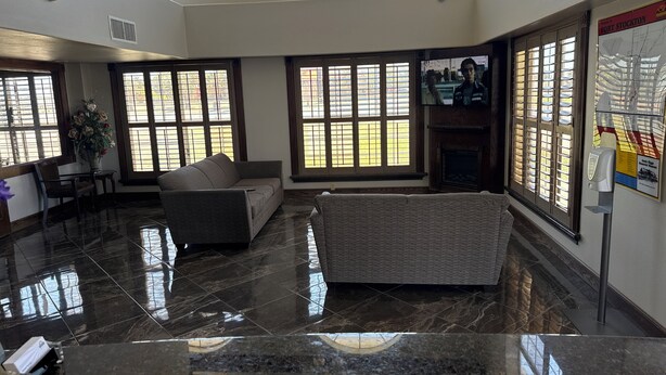 A spacious lobby with a high ceiling, large windows, a fireplace, and a reception desk. - Days Inn by Wyndham Fort Stockton (Fort Stockton)