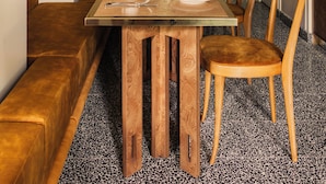 A dining area with a long table, chairs, and a bench.