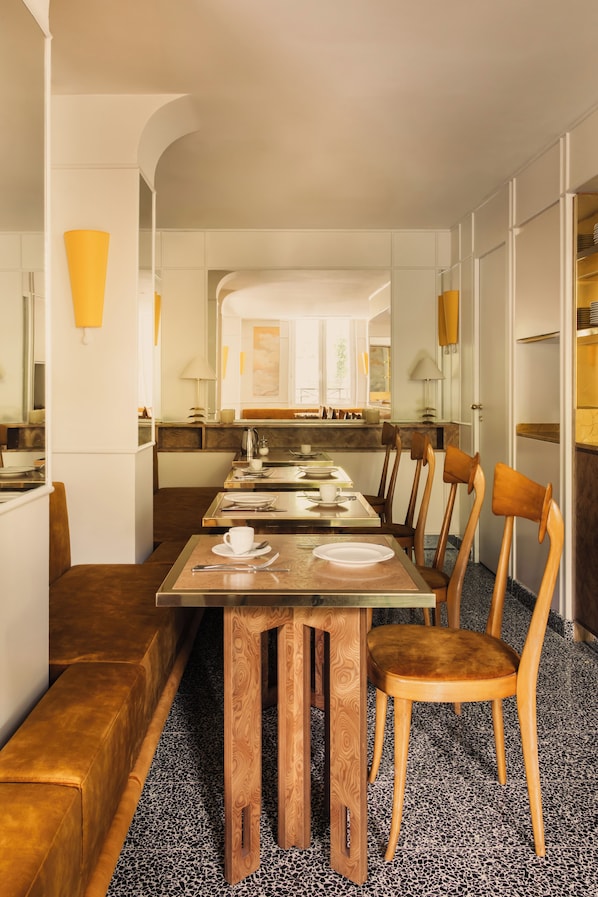 A dining area with a long table, chairs, and a bench.