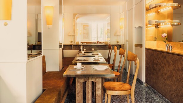 A hotel dining area with a long table, chairs, and a kitchen visible in the background. - Hôtel Blanca (Paris)