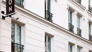A multi-story building with a sign that reads 'STON' on the facade. - Hôtel Blanca (Paris)