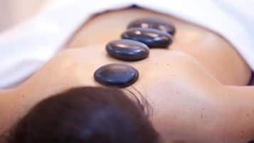 A massage therapy table with a person lying face down, receiving a back massage.