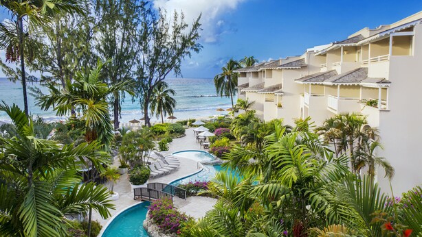 A resort with a pool, palm trees, and ocean views. - Bougainvillea Barbados (Maxwell)