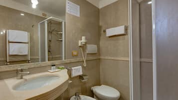 Un baño con lavamanos, inodoro y ducha.