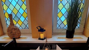 A dining table set for four with a pitcher of water, plates, cutlery, and a candle holder.