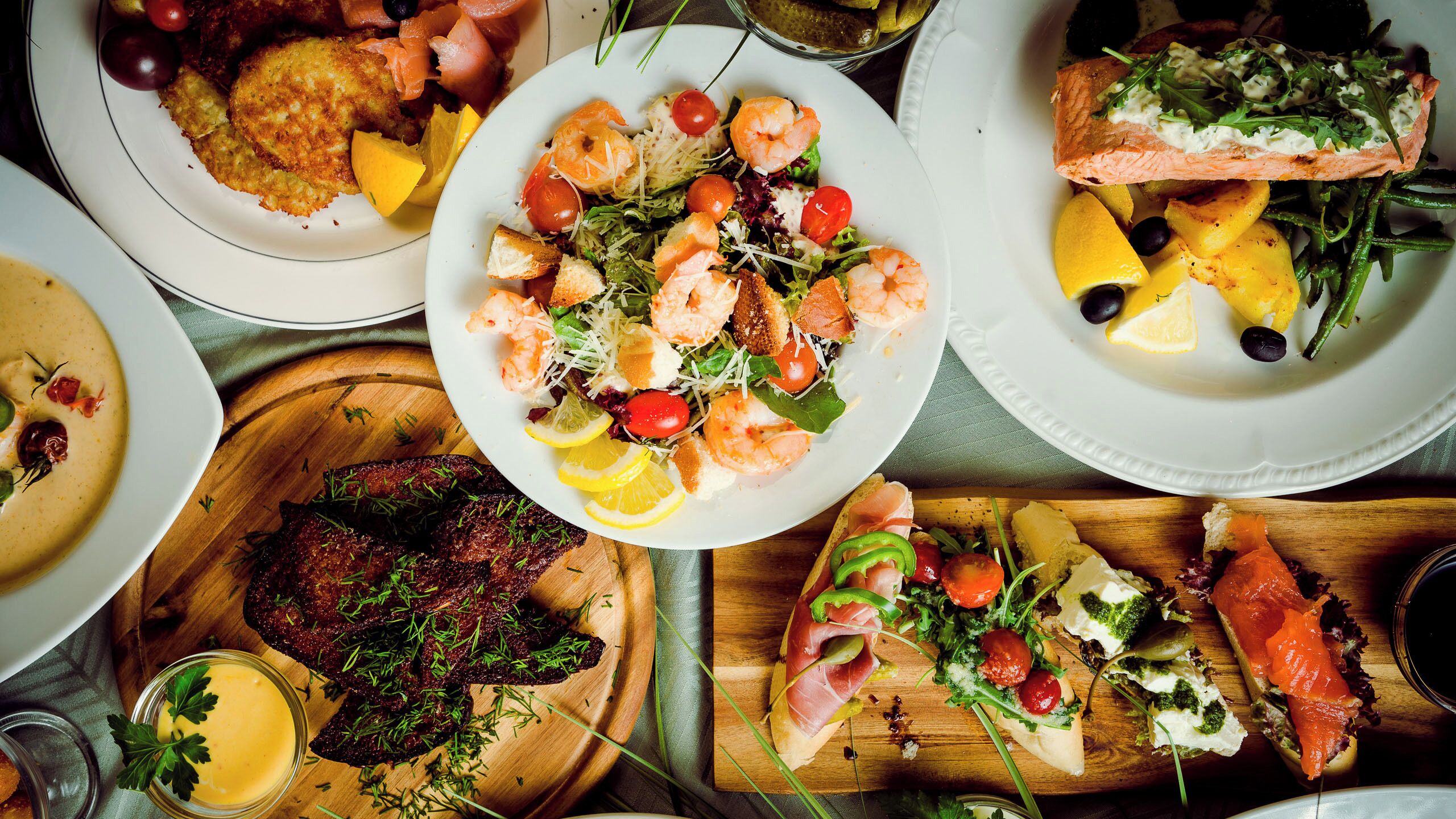Diversos platos con camarones, salmón y verduras.
