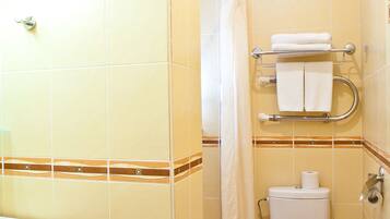 Une salle de bain avec des toilettes, un lavabo et un rideau de douche.