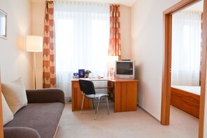 Habitación triple básica, 1 habitación | Área de sala de estar | Televisión LCD 