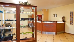 A reception area with a wooden reception desk, glass display cases, and a tiled floor.