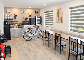 Una cocina moderna con una bicicleta, comedor con sillas y obras de arte en las paredes.