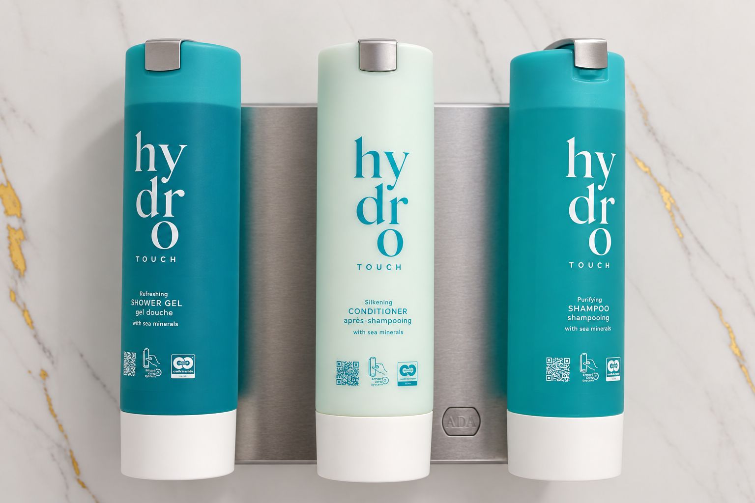 Trois flacons de produits de la gamme Hydra Touch : gel douche, après-shampoing et shampoing, chacun étant doté d’un code QR et de symboles écologiques.