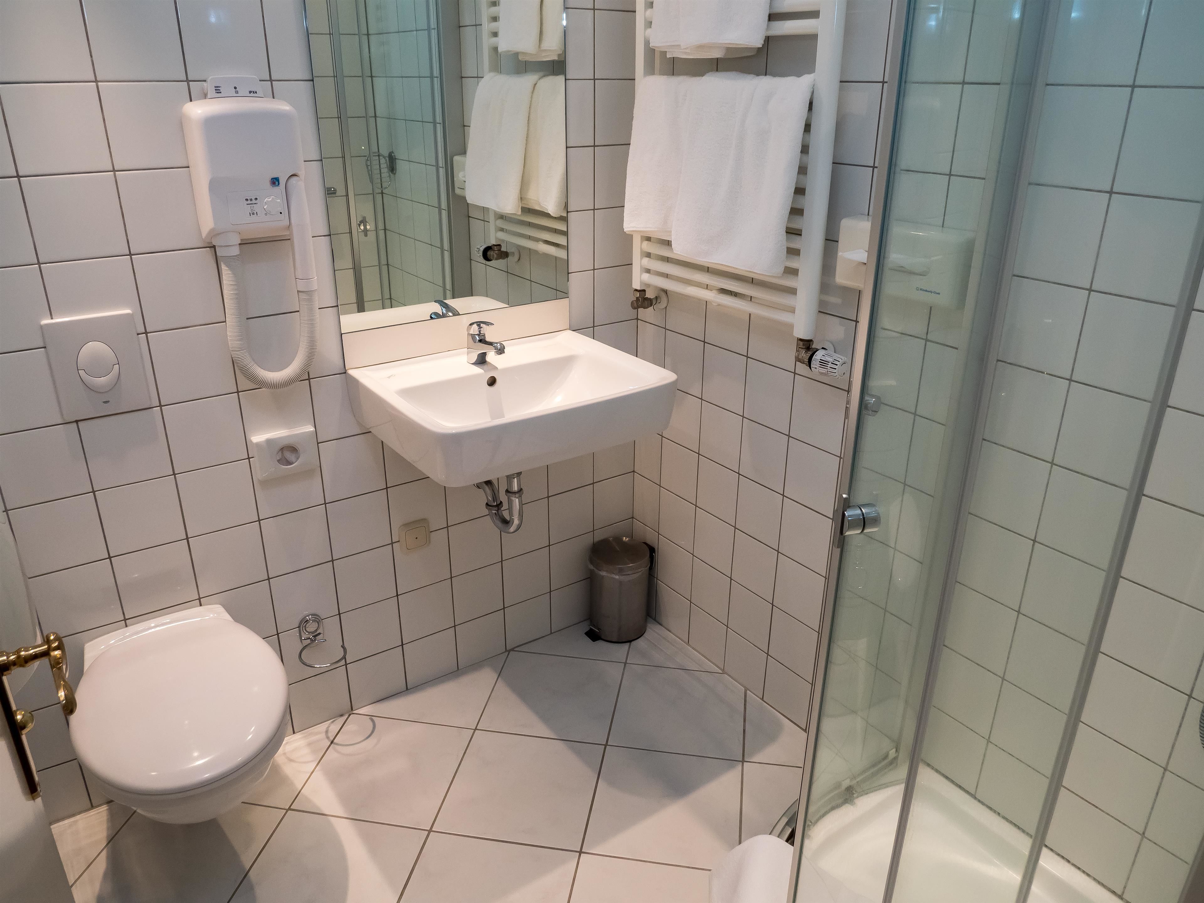 Un baño con inodoro, lavabo y ducha.