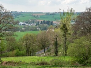 A rural landscape with rolling green fields, scattered trees, and a few houses in the distance. - Best Western Hotel Slenaken (Heijenrath)