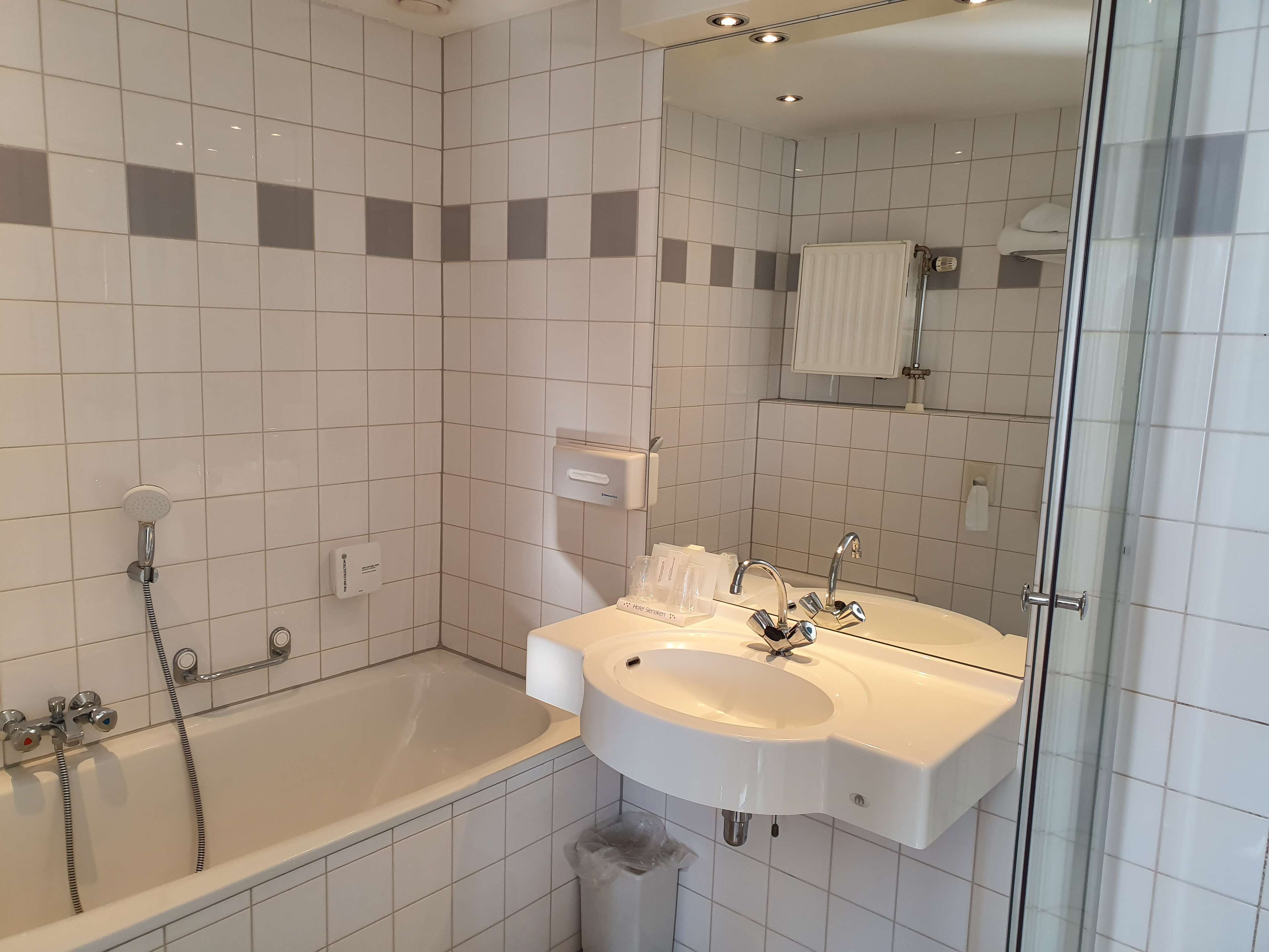Un baño moderno con bañera, lavamanos y cabina de ducha de vidrio.