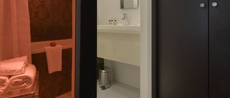 A bathroom with a white sink, mirror, and towel rack.