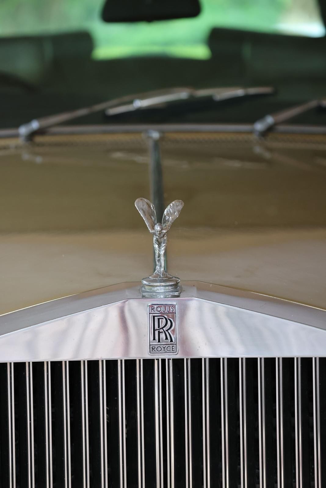 A close-up of a Rolls-Royce emblem on a vehicle's hood.
