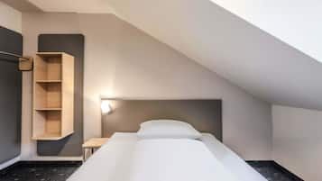Ein kleiner, moderner Raum mit einem Bett, einem Holzbodenregal und einem Nachttisch.