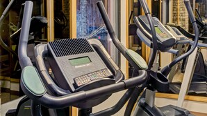 Un gimnasio con múltiples cintas de correr, cada una equipada con pantallas digitales y paneles de control.