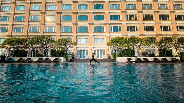 A hotel with a large pool, multiple floors, and outdoor seating areas. - Equatorial Ho Chi Minh City (Ho Chi Minh City)