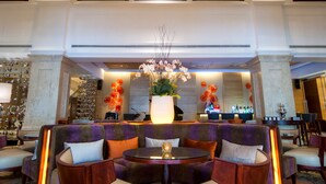 A lobby with a stained glass ceiling, a reception desk, and seating areas. - Equatorial Ho Chi Minh City (Ho Chi Minh City)