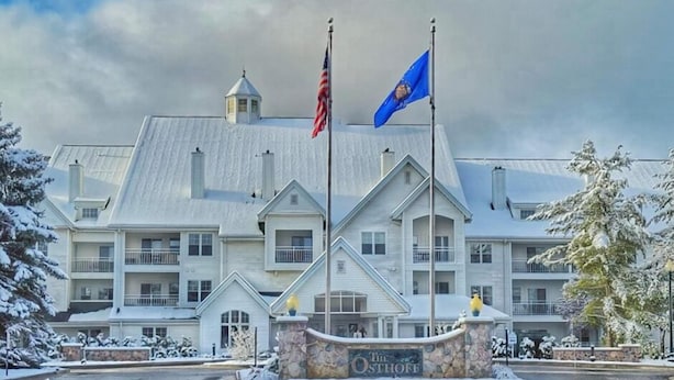 A large building with a stone entrance, two flags, and a sign that reads 'The Osborn.' - The Osthoff Resort (Elkhart Lake)