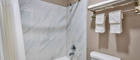 A bathroom with a bathtub, a shower, and a toilet.