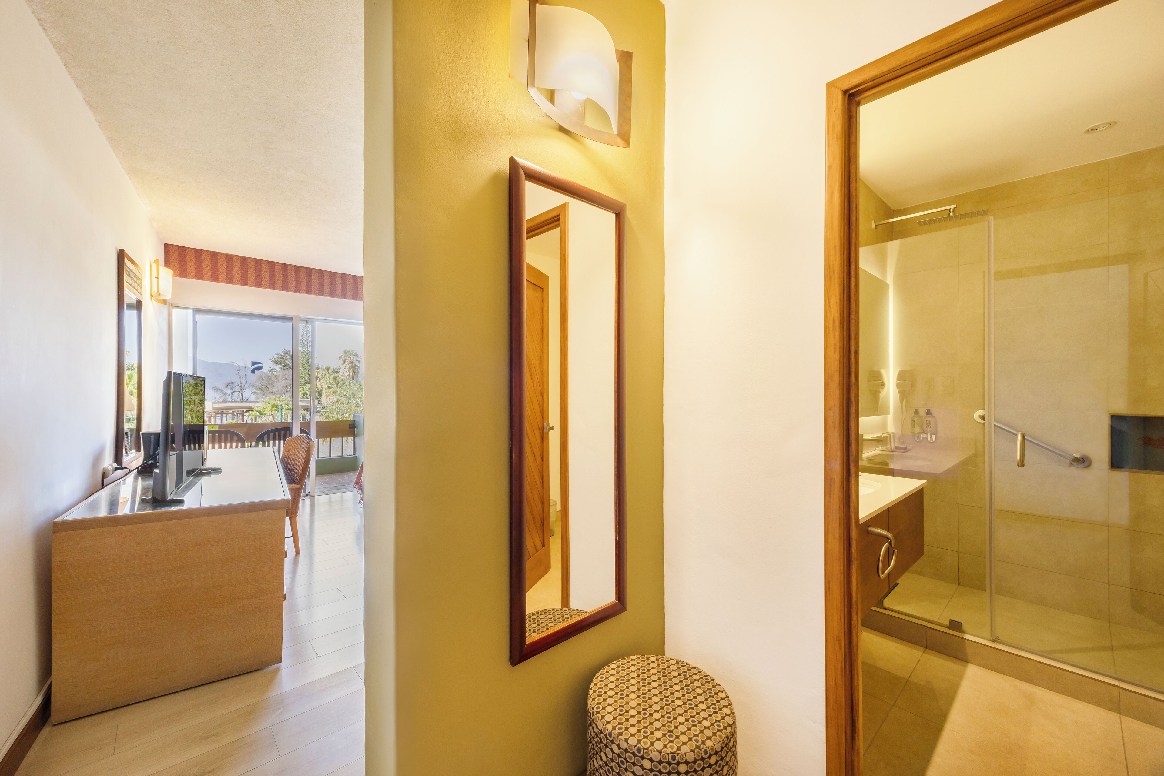 A modern bathroom with a glass shower, a wooden vanity, and a mirror on the wall.