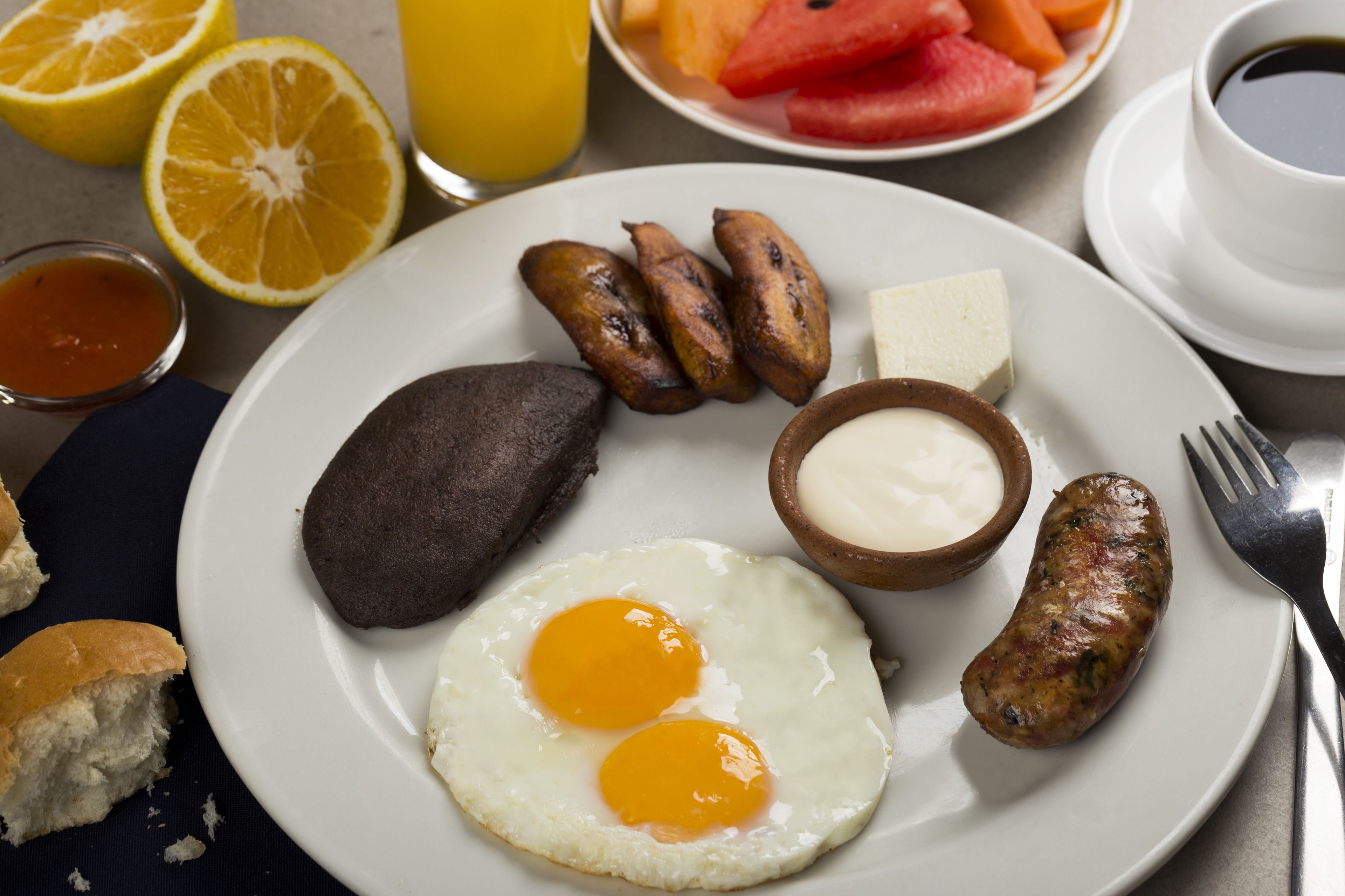 A breakfast plate with eggs, sausages, hash browns, and toast.