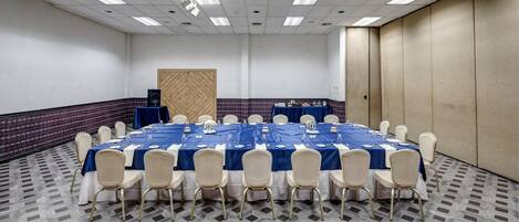 A conference room with a long table, chairs, and a patterned floor.