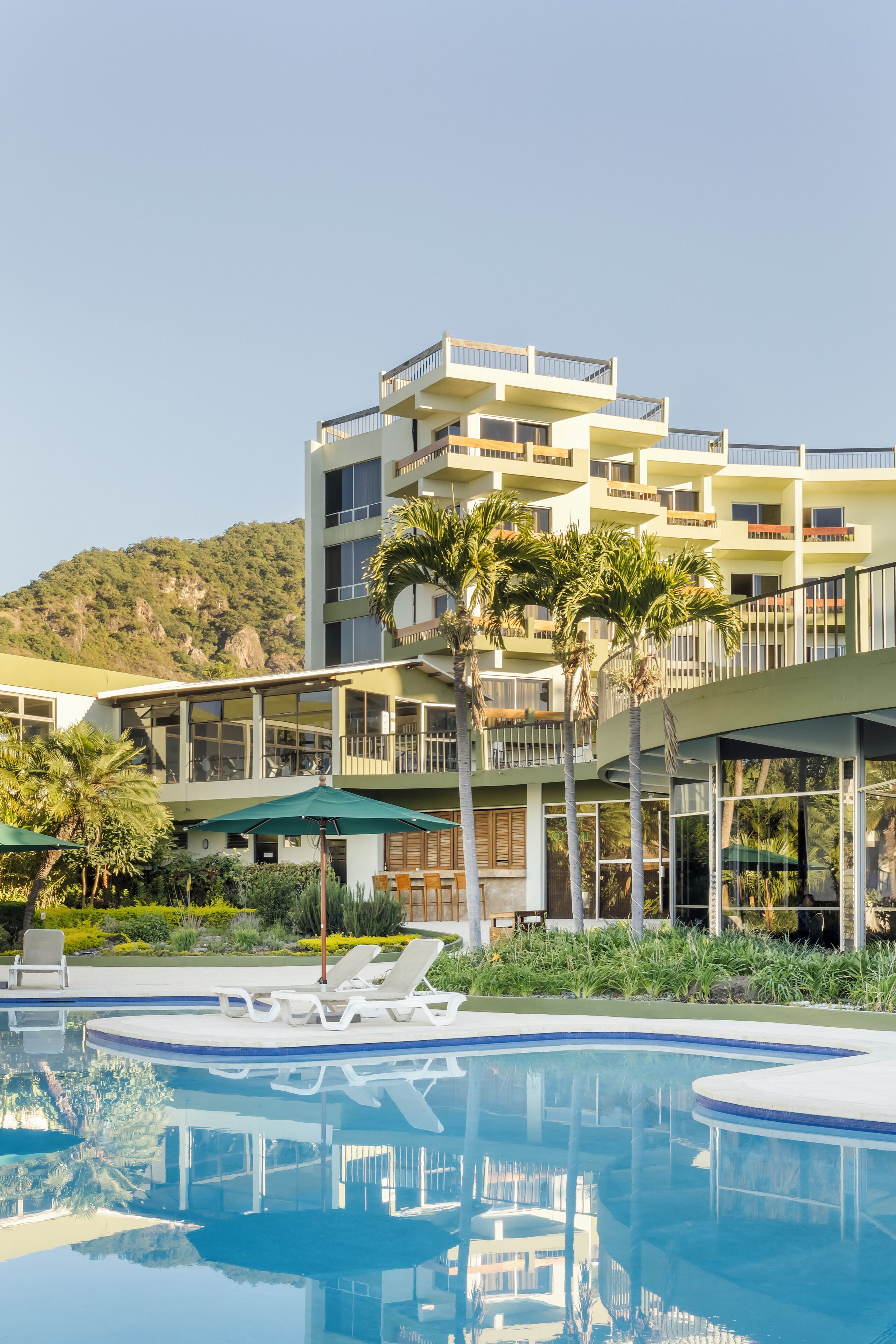 Alberca al aire libre, sombrillas en la alberca y camastros 