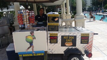 Un carrito de hot dogs con un menú que ofrece Nathan's Hotdog y Nathan's Combo, con precios de 4,50 y 5,50 dólares respectivamente.