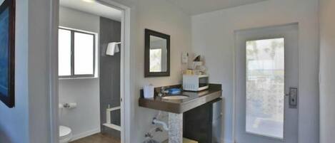 A modern bathroom with a toilet, sink, and mirror.
