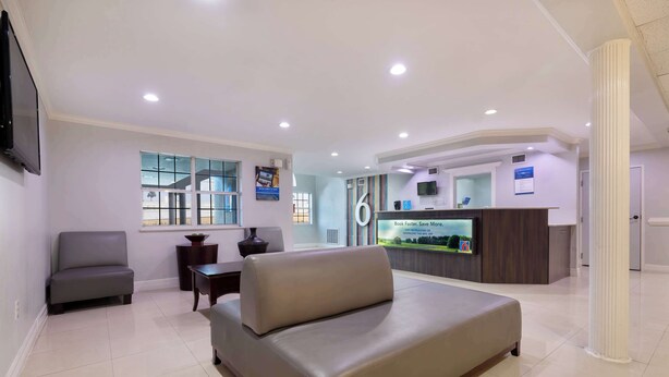 A modern reception area with a reception desk, a sofa, and a television.