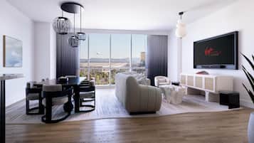 Uma sala de estar moderna com uma televisão grande, uma área de jantar e vista para a cidade.