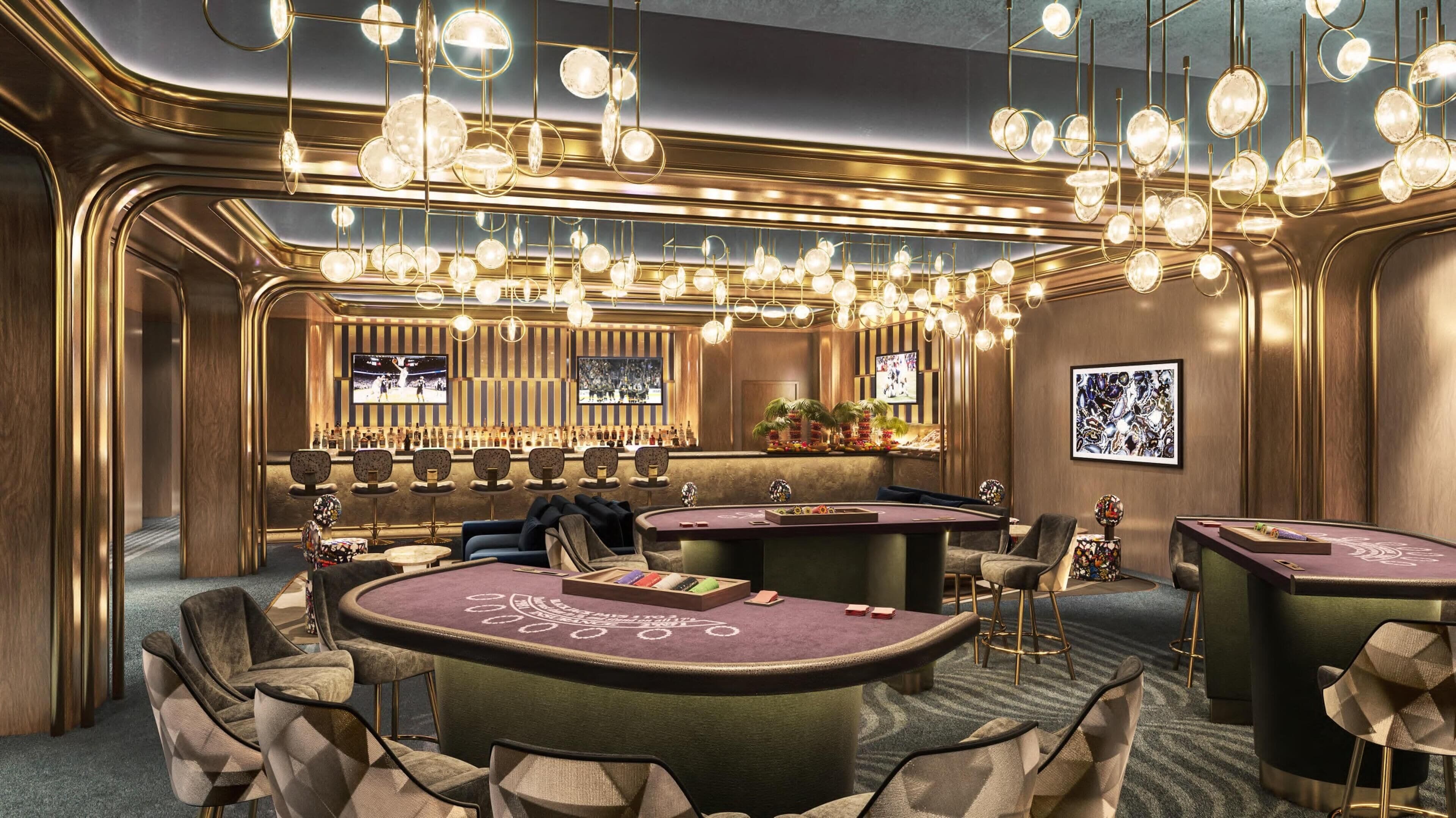 A luxurious bar area with multiple gaming tables, comfortable seating, and a sophisticated chandelier.