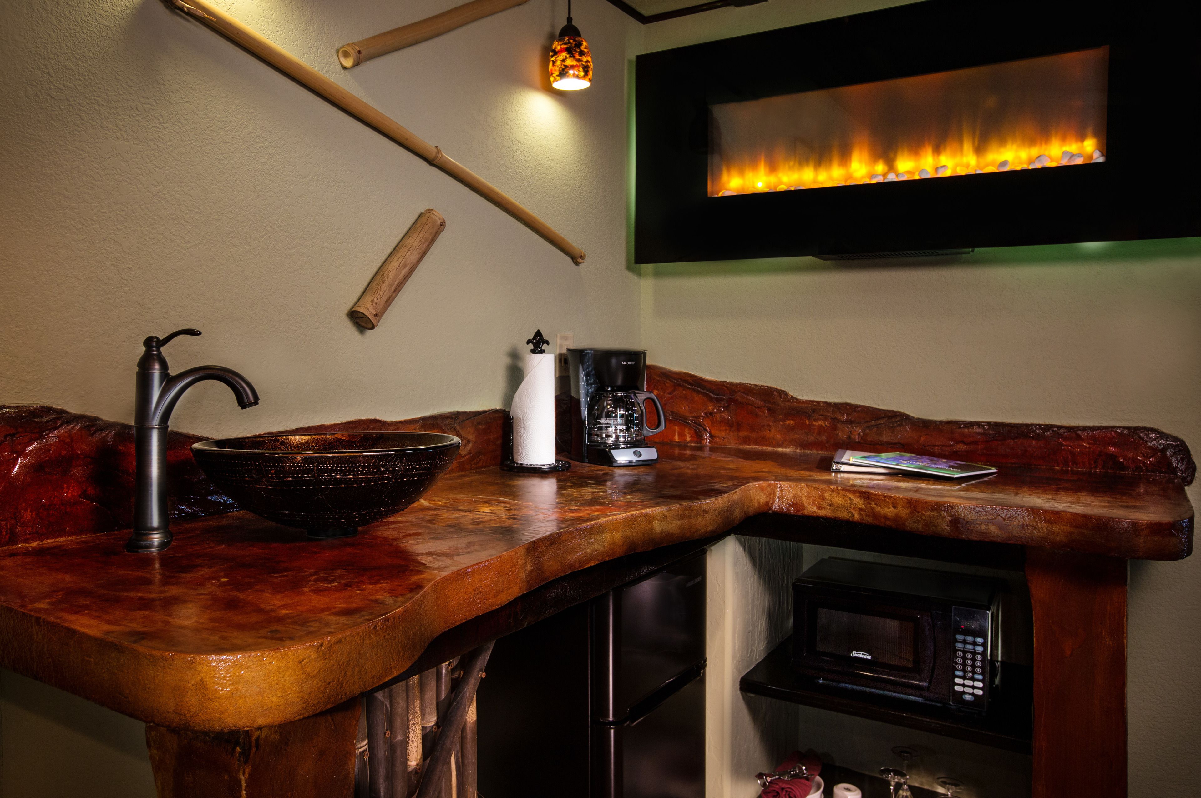Une cuisine avec un plan de travail en bois, une machine à café, un évier et un four à micro-ondes.
