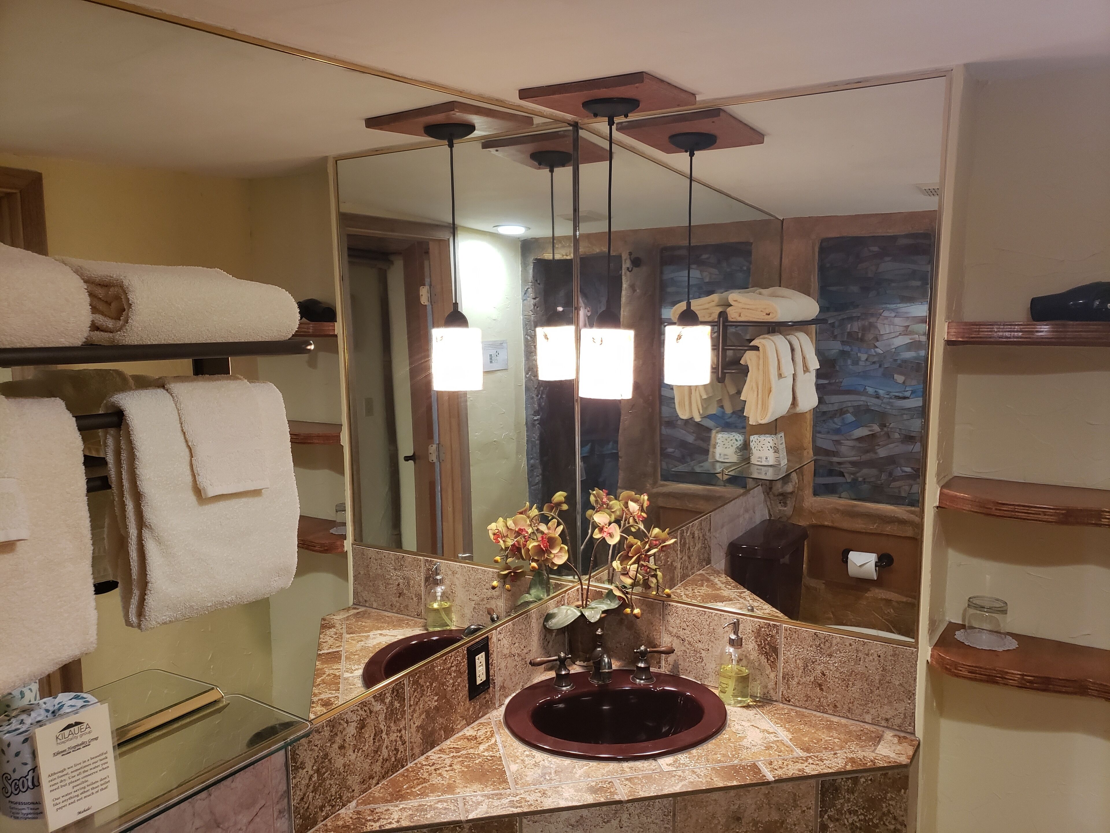 A bathroom with a marble sink, a mirror, and a towel rack with folded towels.