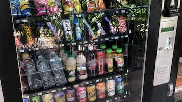 Un distributeur automatique proposant une variété de collations, de boissons et d’eau en bouteille.