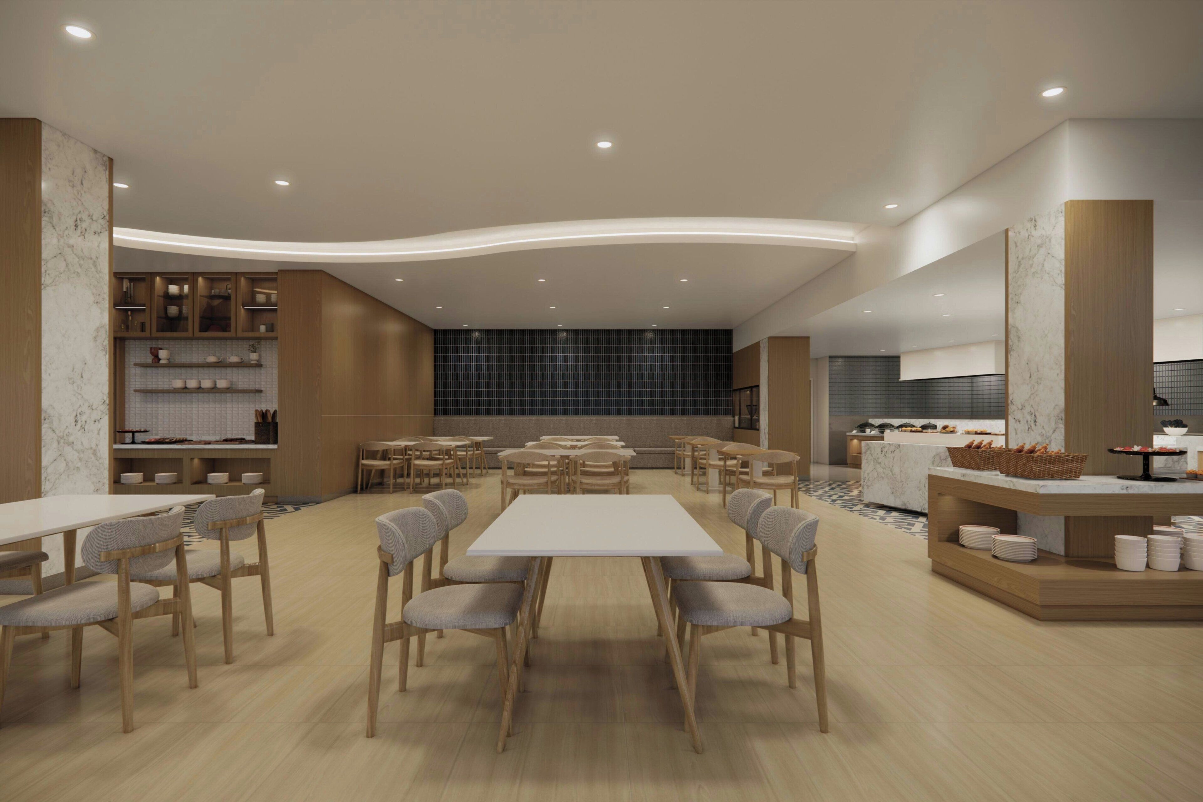 A modern dining area with a central table, surrounding chairs, and a buffet counter.