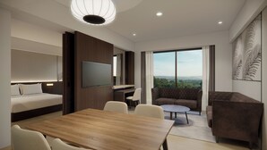 A modern hotel room with a bed, a TV, a dining table, and a sofa. - Courtyard by Marriott Manado (Manado)