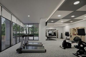 A modern gym with treadmills, stationary bikes, and exercise equipment.