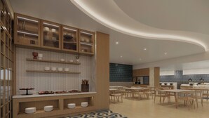 A modern kitchen with wooden cabinets, white tiled backsplash, and a patterned floor. - Courtyard by Marriott Manado (Manado)