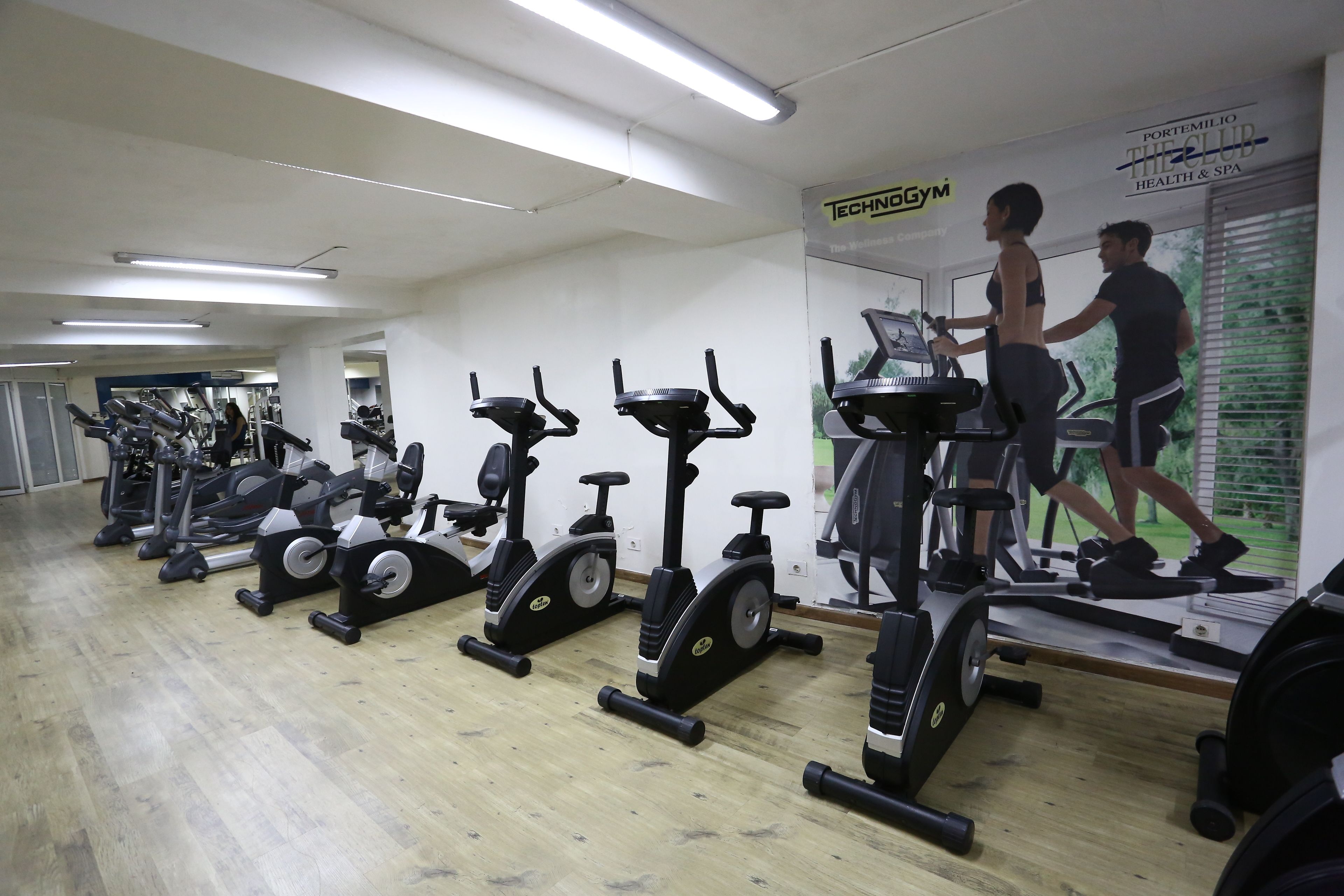 Un gimnasio con bicicletas estáticas, cintas de correr y máquinas de pesas.