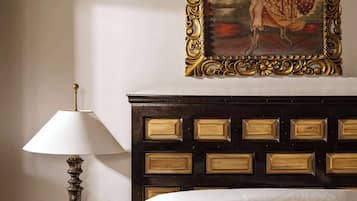 Un lit avec une tête de lit, une table de chevet avec une lampe et un tableau encadré au mur.