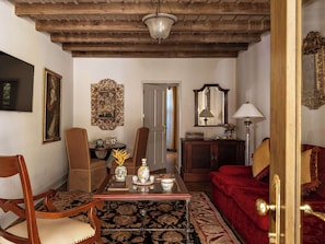 A traditional living room with wooden furniture, a patterned rug, and decorative items.