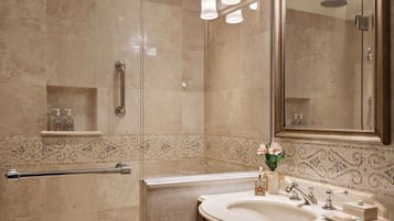 A modern bathroom with a glass-enclosed shower, a vanity with a large mirror, and a decorative tile backsplash.