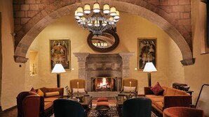 Un rincón acogedor con chimenea, asientos cómodos y pinturas decorativas.