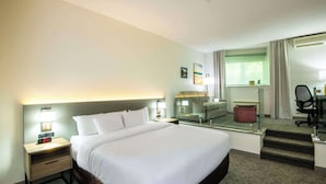 A hotel room with a large bed, a desk with a chair, a mirror, and a small seating area. - Comfort Inn Mont Laurier (Mont-Laurier)