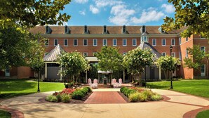 A large brick building with a central courtyard, surrounded by well-maintained lawns and trees. - College Park Marriott Hotel & Conference Center (College Park)