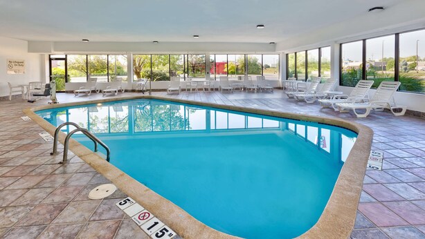 An indoor swimming pool with clear water, tiled floor, and white lounge chairs. - Hampton Inn Columbus/Delaware I-71 North (Sunbury)